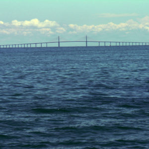A suspended bridge in the distance over ocean waters.